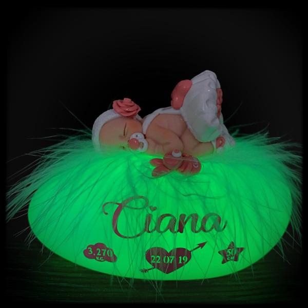 Fimo baby girl dressed in a gown on a personalized illuminated pebble with the name, date of birth, weight, and height