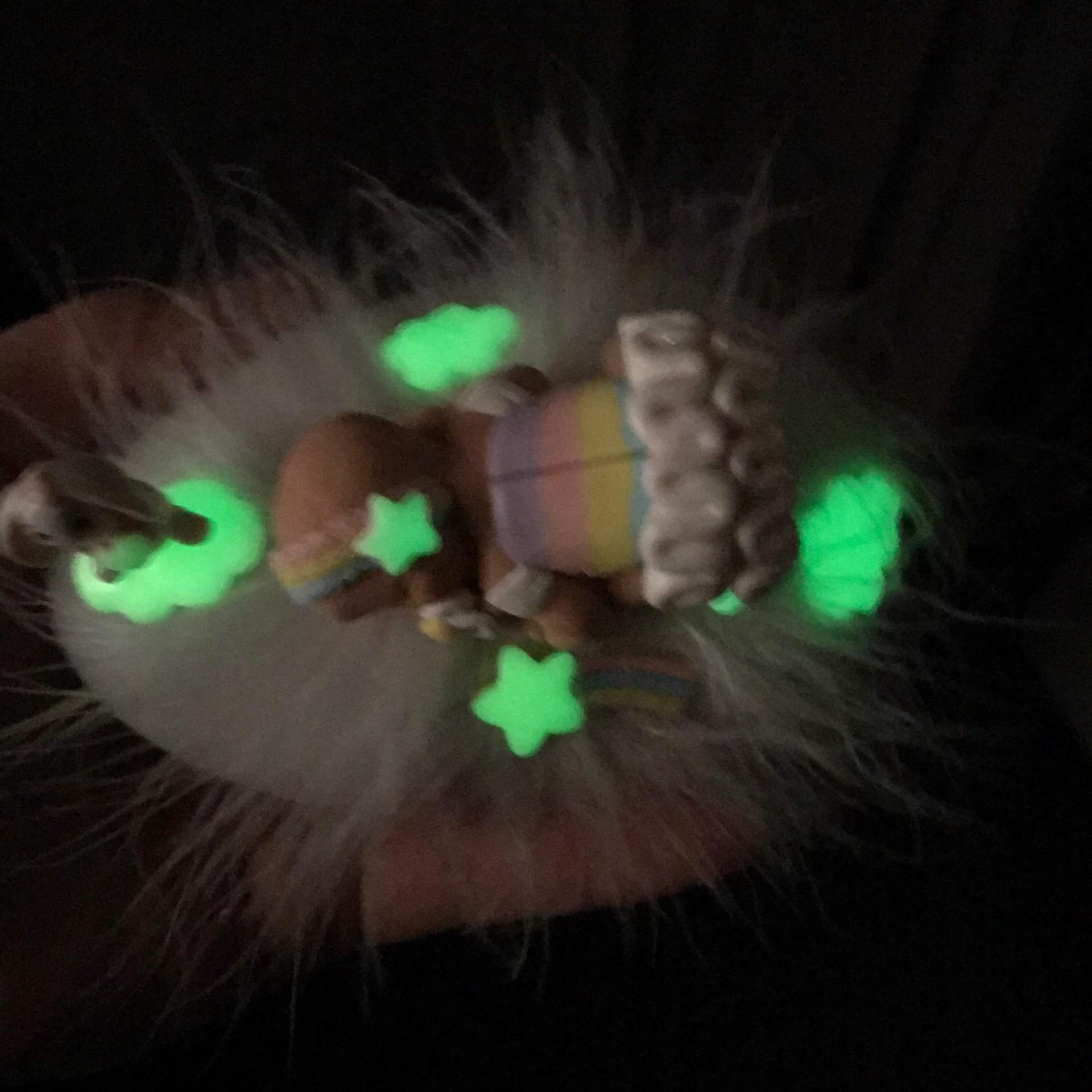 Baby girl LED night light turned off with miniature glow-in-the-dark decorations, view from above