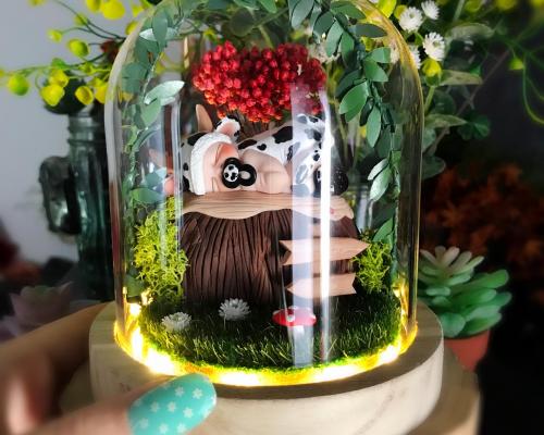 Cloche LED enchantée en dôme de verre avec un bébé vache sculpté à la main dans un jardin miniature personnalisé avec les éléments de naissance