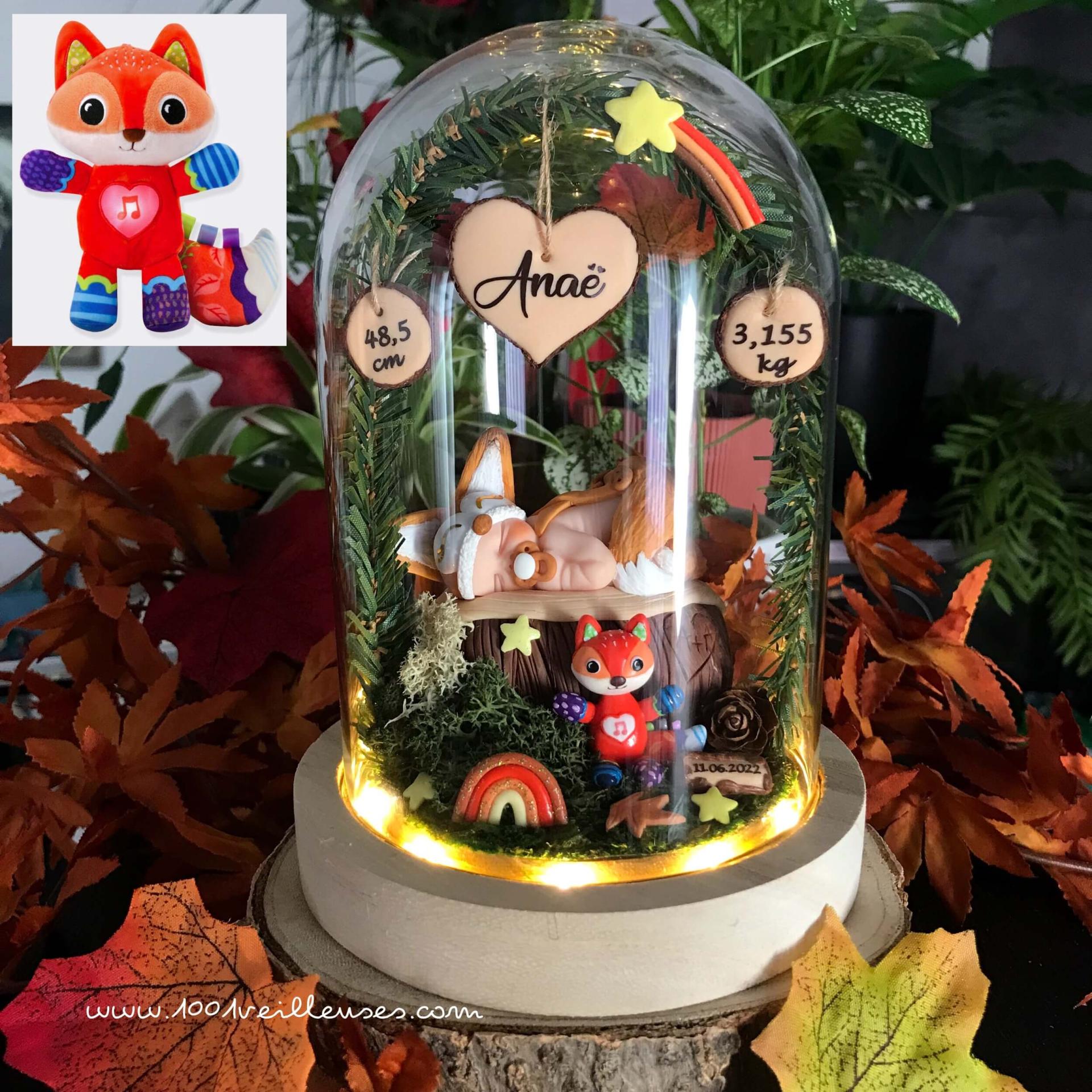 Handcrafted nightlight under a glass bell, baby dressed as a fox, in an enchanted forest with a reproduction of its fox cuddly toy