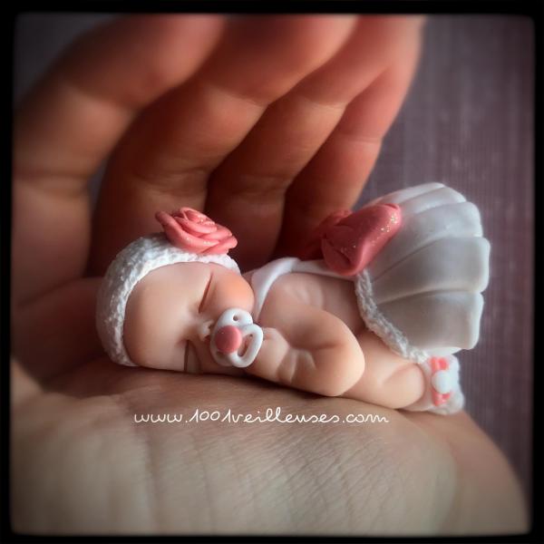 Adorable bebé niña de fimo, terminada de esculpir y colocada en la mano