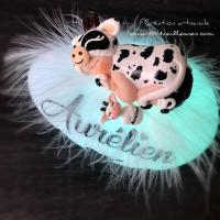 Custom LED pebble-shaped nightlight with a small baby dressed as a cow, hand-sculpted with miniature elements