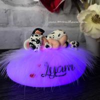 Personalized night light in the shape of a luminous pebble with a polymer clay baby dressed as a Dalmatian next to a gift box