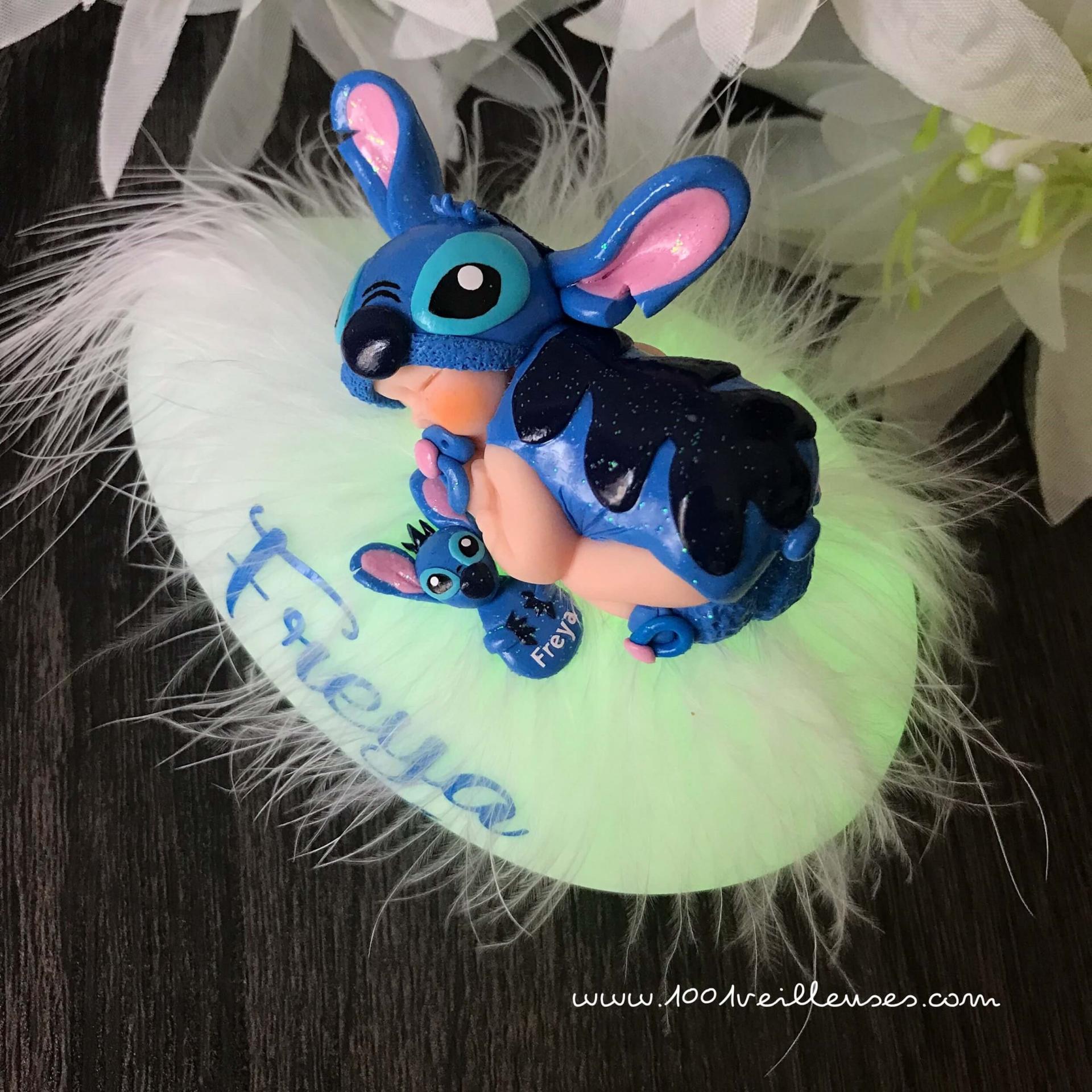 Multicolored lighted pebble with a baby sculpted in polymer clay dressed up as Stitch, top view