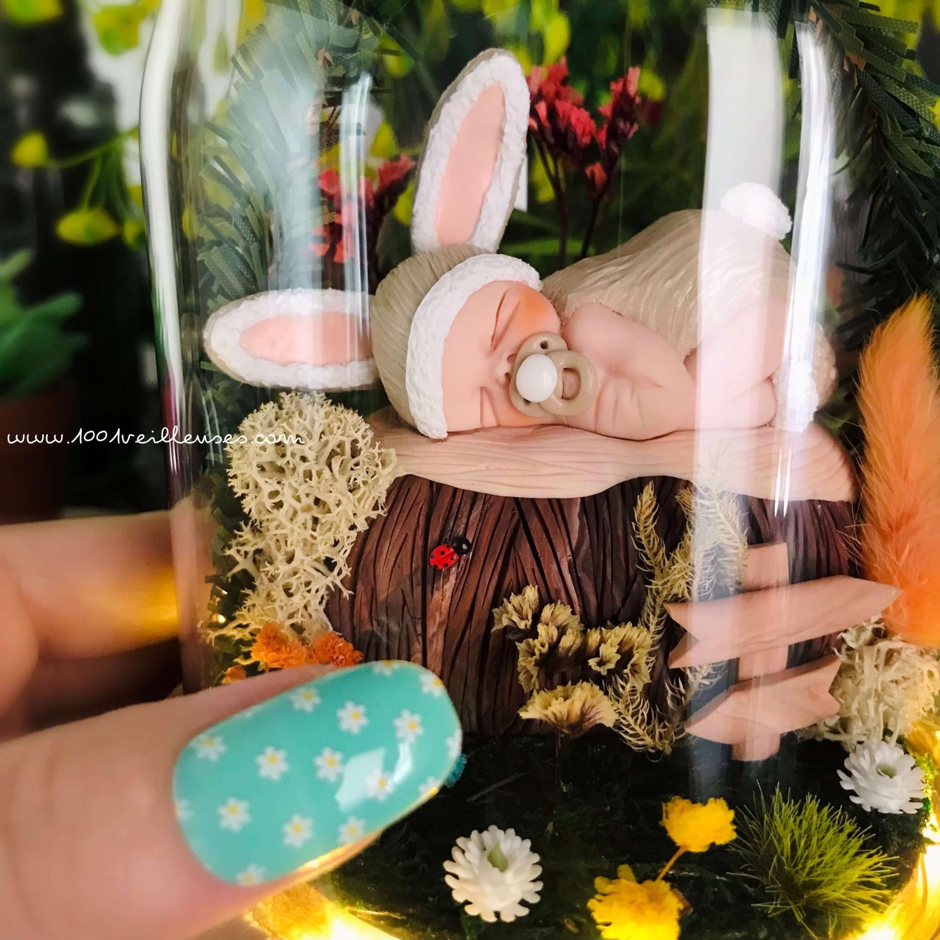 Small baby rabbit sleeping sculpted in fimo inside its glass bell, close-up view