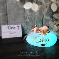Multicolored glowing pebble with a little girl sculpted in polymer clay on the unicorn theme, accompanied by her personalized note beside