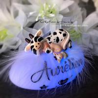 LED nightlight baby cow, lit up and personalized with birth elements, angled view
